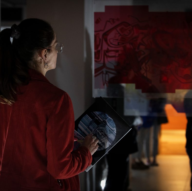 Zdjęcie: kobieta przygląda się pracy artysty w galerii